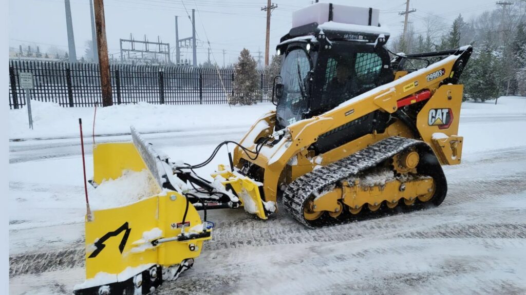 A yellow color JCB removing snow